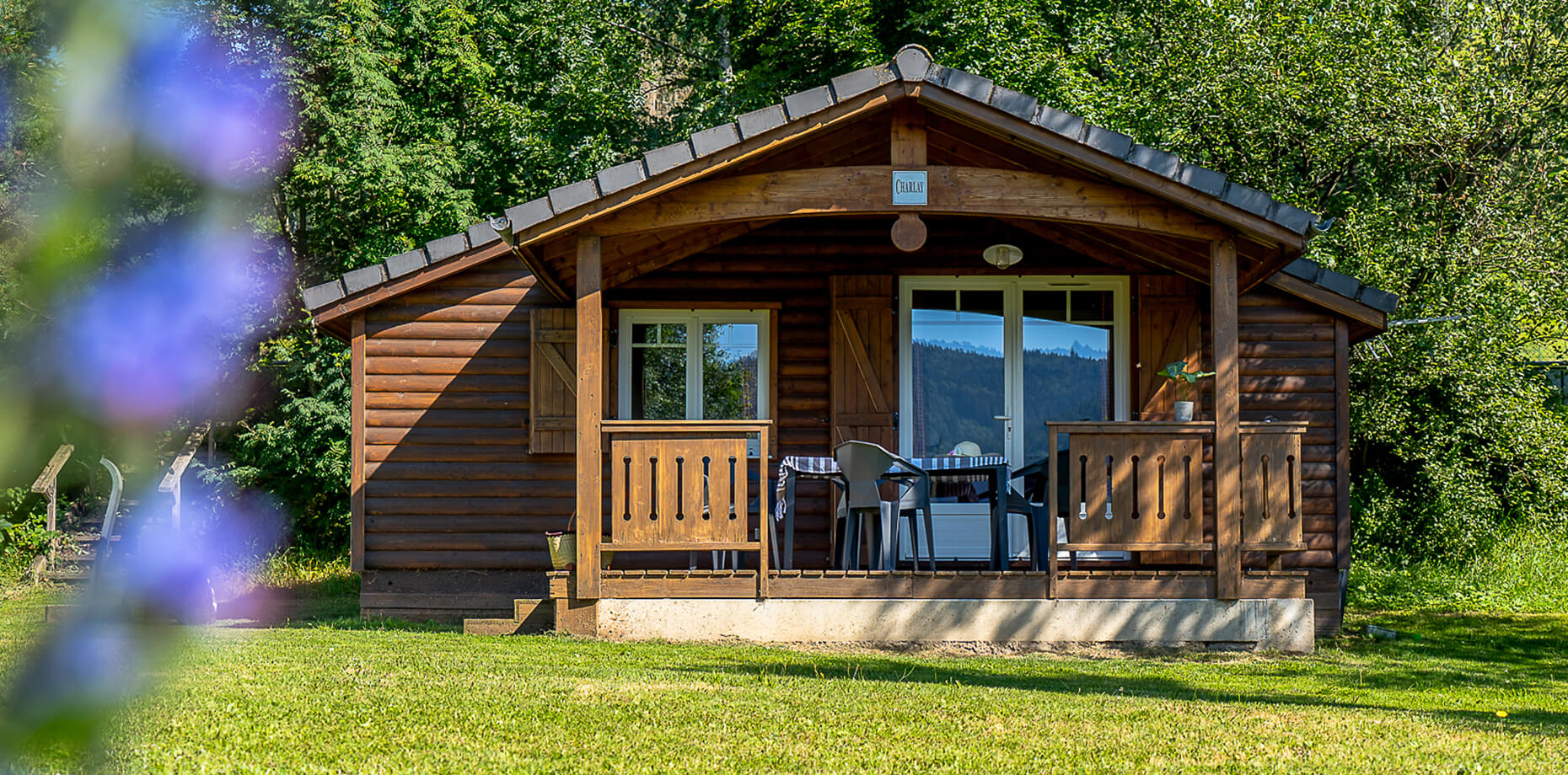 Vue extérieure du chalet CHARLAY 22 avec terrasse en location au camping Lefébure en Alsace