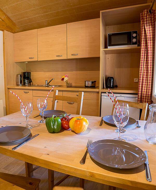 Cuisine et coin repas du chalet Charlay 21 en location au camping Lefébure, camping 2 étoiles en Alsace
