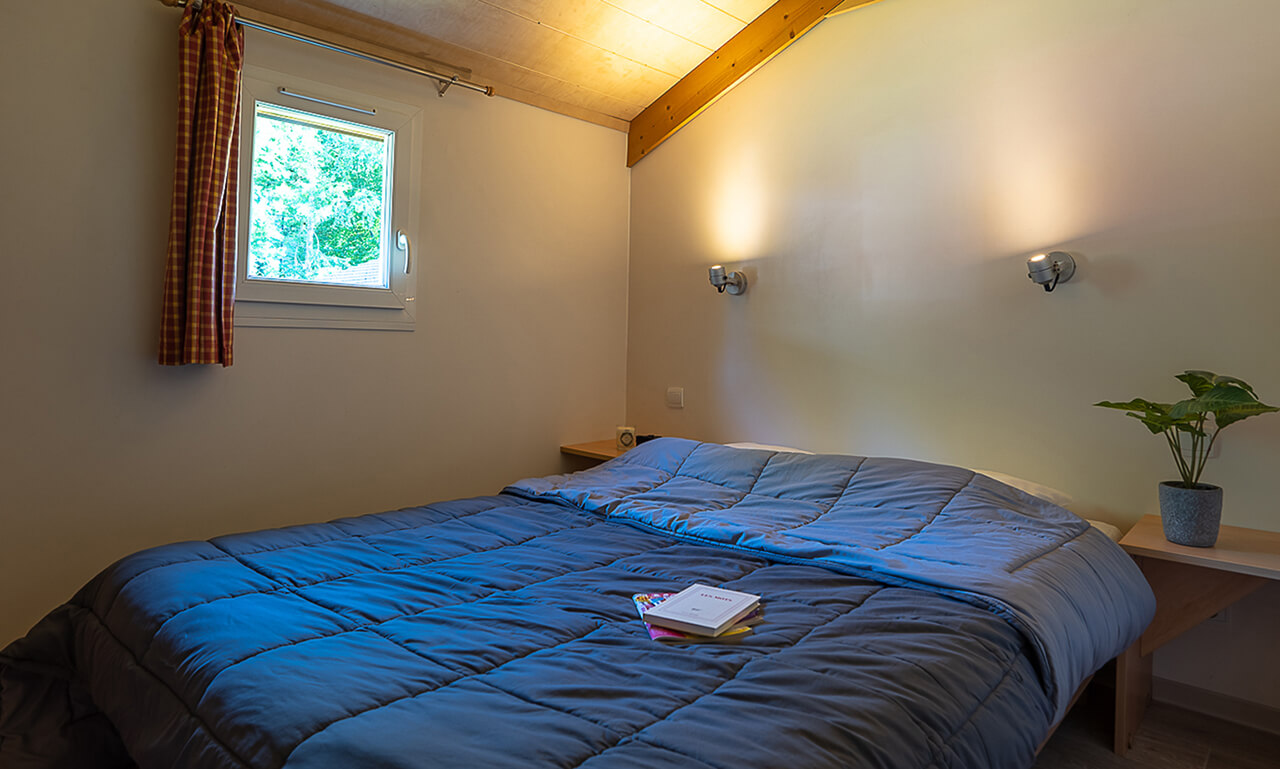 Chambre avec lit double du chalet Forester en location au camping Lefébure près de Colmar