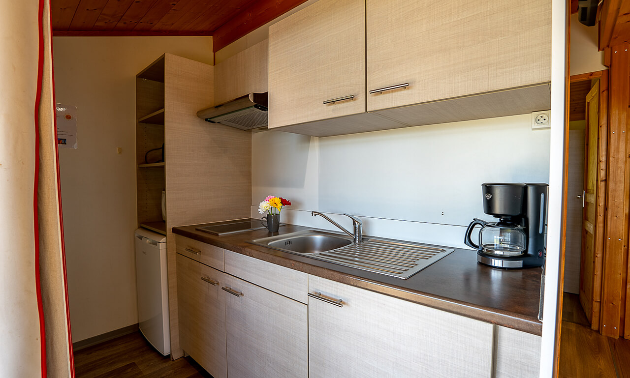 Cuisine du chalet TAHOE avec lit deux places en location au camping Lefébure en Alsace