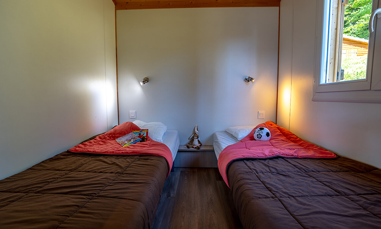Chambre du chalet TAHOE avec 2 lits une place en location au camping Lefébure en Alsace